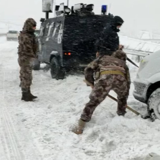 Kar nedeniyle yolda kalan servis aracının yardımına Özel Harekat polisleri koştu